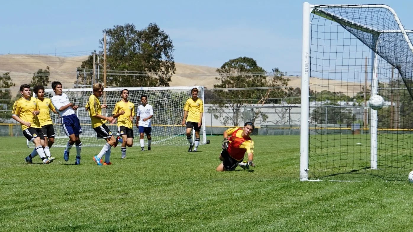 Youth soccer team in colorful uniforms practicing on a grass field